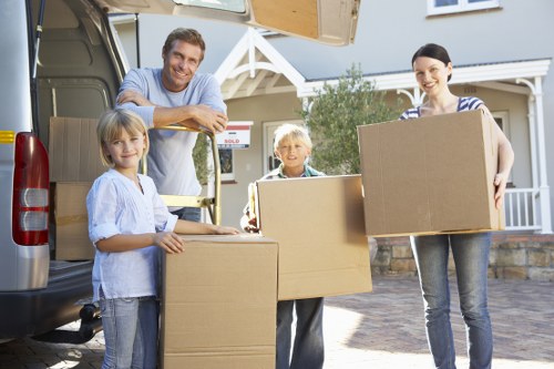 Movers carrying household items through a narrow West London staircase