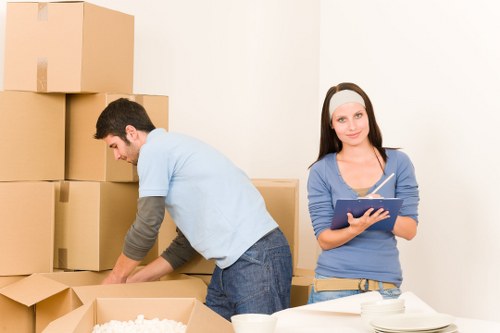 Professional movers carrying furniture in a Notting Hill flat building